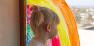 Kleines Mädchen mit Regenbogen-Bild