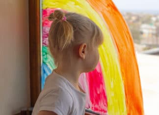 Kleines Mädchen mit Regenbogen-Bild