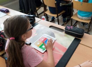 Grundschülerinnen und Grundschüler lernen an iPads.