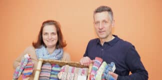 Miriam Buhl und Ottmar Stephan vom Caritasverband für die Diözese Osnabrück verkaufen bunte Wollsocken für den guten Zweck. / Foto: Caritas / Nadin Kohlbrecher