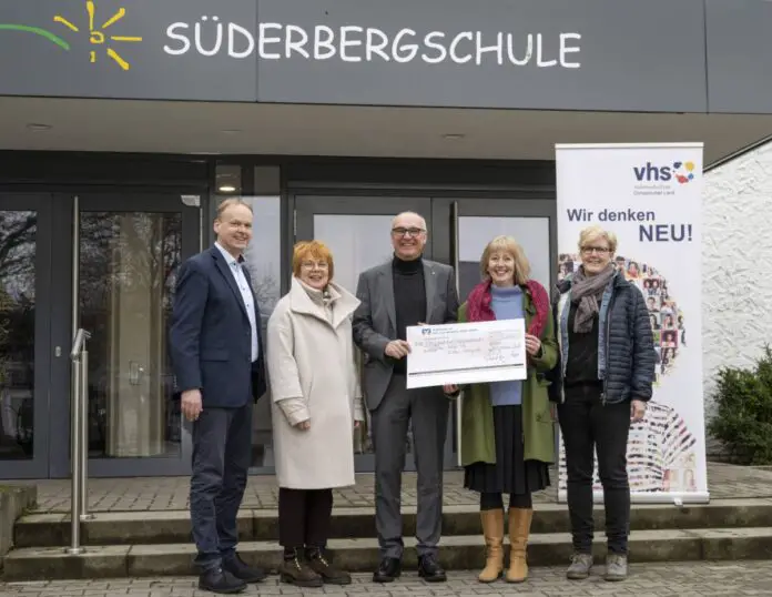 Bankvorstand Thomas Ruff überreicht den symbolischen Spendenscheck an Jörg Temmeyer und die Vertreter/-innen der vhs Osnabrücker Land. (von links) Jörg Temmeyer, Karin Patzelt-Borgschulte, Thomas Ruff, Tanja Pöhler, Ann-Britt Striemer / Foto: vhs Osnabrücker Land