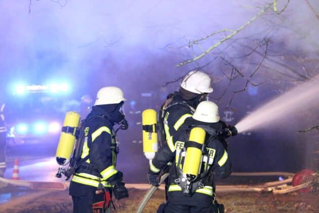 Feuerwehrleute mit Atemschutz an Strahlrohr