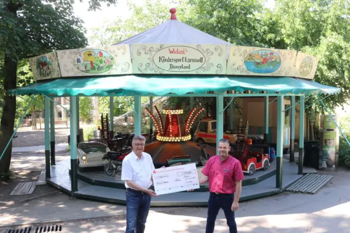 Karussell fahren für die Osnabrücker Elefanten: Dank des Fahrgeschäfts im Zoozentrum konnte Carsten Wieland (r.) Dr. E.h. Fritz Brickwedde, Präsident der Zoogesellschaft Osnabrück e.V., (l.) eine Spende von 11.000 Euro überreichen. / Foto: Zoo Osnabrück (Lara Holzkamp)
