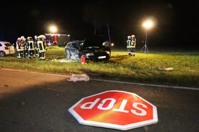 Beschädigtes Straßenschild vor Unfallfahrzeugen