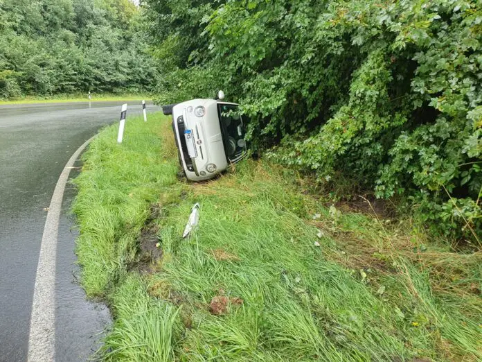 PKW liegt auf Fahrerseite im Grünstreifen, Frontansicht