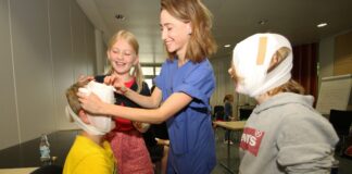 Ferienpass-Kurse „Erste Hilfe für Kinder“ im Klinikum: Alica van der Veen und Dr. Guido Teckemeyer übten dabei mit den Mädchen und Jungen auch das Anlegen von Verbänden. / Foto: Jens Lintel