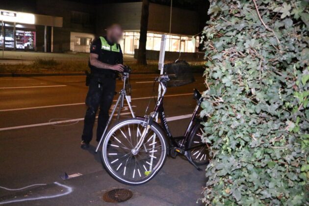 Polizist fotografiert beschädigtes Fahrrad