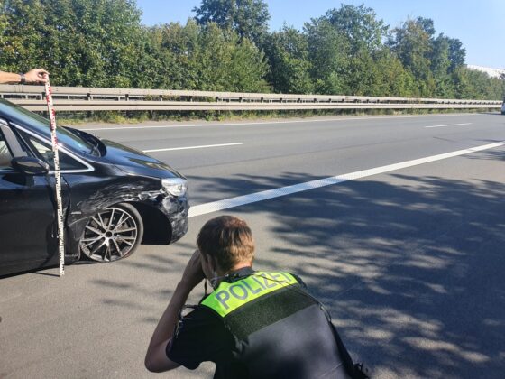 Polizist fotografiert Schäden am BMW