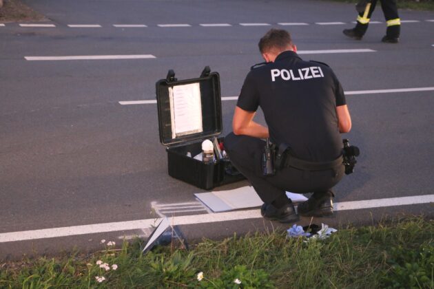 Polizist mit Hilfsmitteln zur Unfallspurenmarkierung