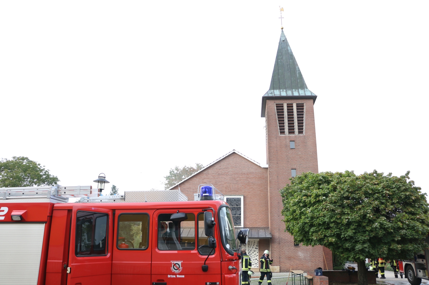 Feuerwehr vor der Kirche mit Blick auf den Kirchturm