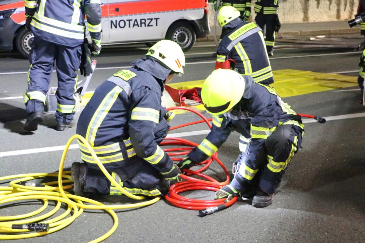 Feuerwehrleute wickeln Hydraulikschläuche der Rettungsgeräte auf