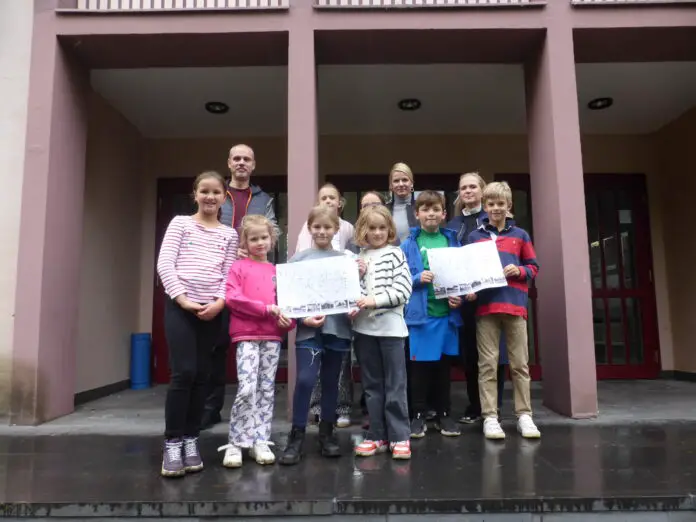 307837P Schülerinnen und Schüler der Rückert- und der Elisabethschule präsentieren die frisch erarbeiteten Schulwegpläne zusammen mit (hinten von links) Malte Wanzek vom städtischen Team Mobile Zukunft, Miriam Spielberg-Siegel, Leiterin der Elisabethschule, und Stefanie Kohlmeyer, die die Rückertschule leitet. / Foto: Stadt Osnabrück, Yannik Kolmer