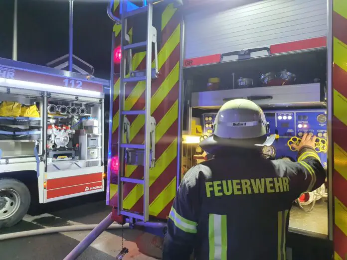Maschinist einer Feuerwehr bedient Pumpe an einem von zwei Feuerwehrfahrzeugen. / Foto: Heiko Westermann